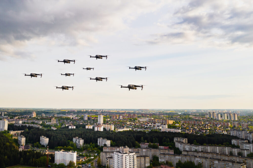 Drones fly over the city's houses. Urban landscape with drones flying over it, quadrocopters flying over the city